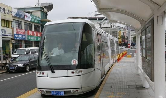 有轨电车是用轮胎走的吗上面好象有个天线吧,它这样怎么拐弯呀